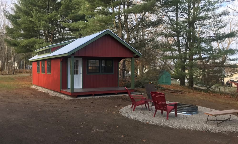 Backyard cabin with fireplace and chairs