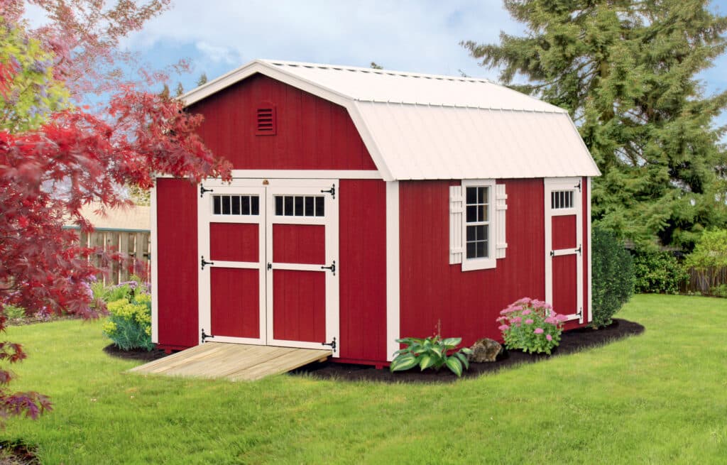 red barn style shed with white trim metal roof and ramp leading up to front doors with transom windows