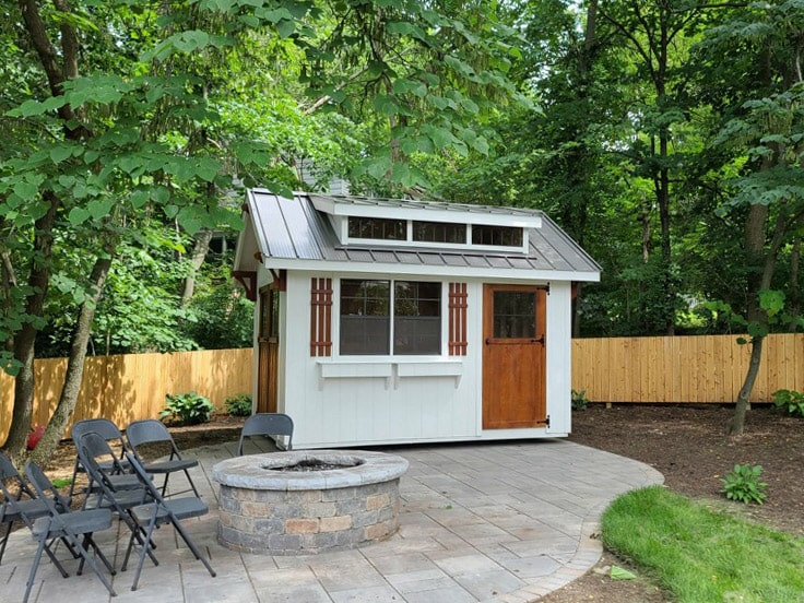 Shed in backyard with patio and fireplace
