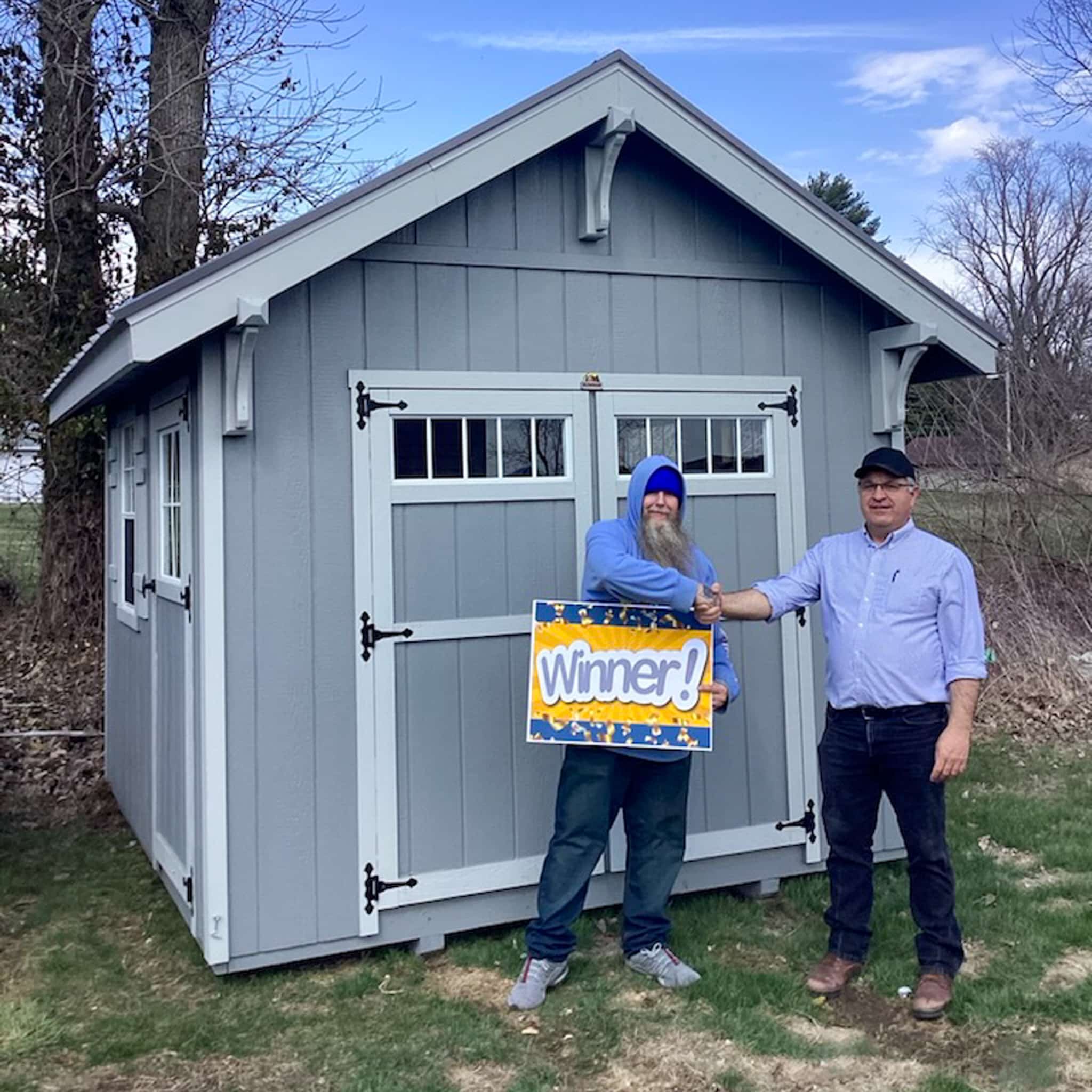 Gray Shed with two men standing in front.